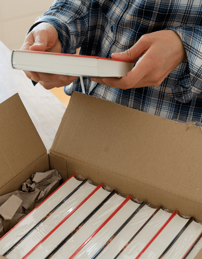 Person unpacking books from a box